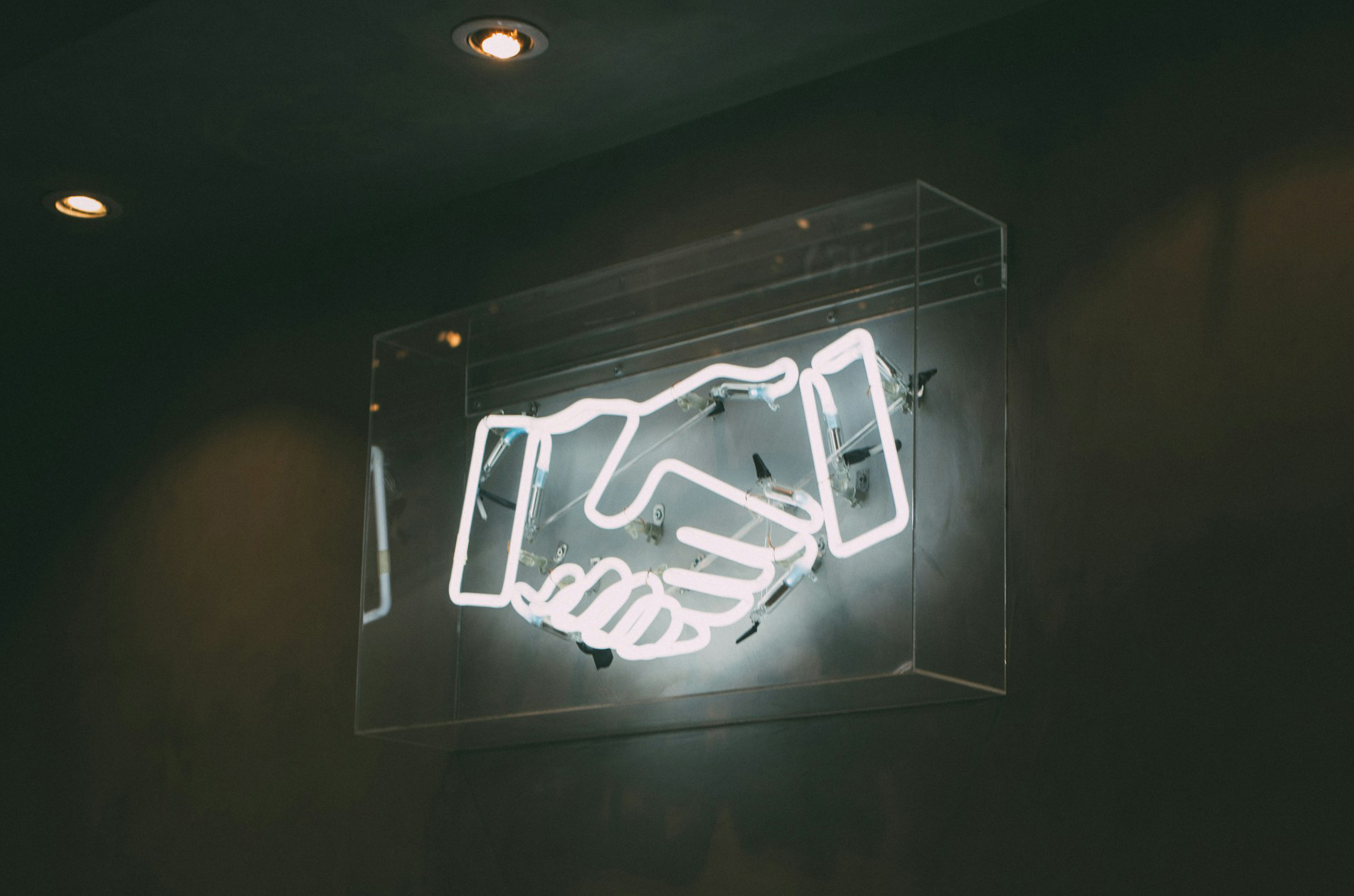 Neon sign of two hands shaking hands